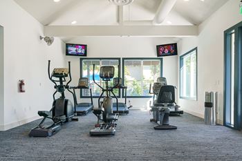 a spacious fitness room with treadmills and cardio machines